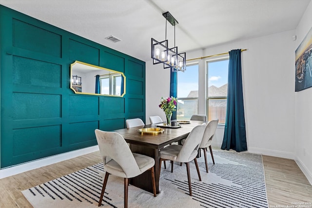 dining space featuring a wealth of natural light, a notable chandelier, and light wood-type flooring