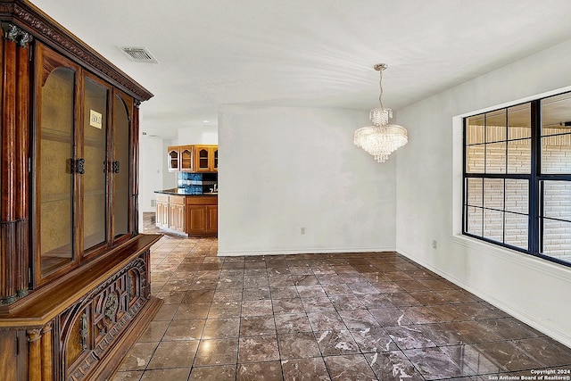 unfurnished room featuring a notable chandelier