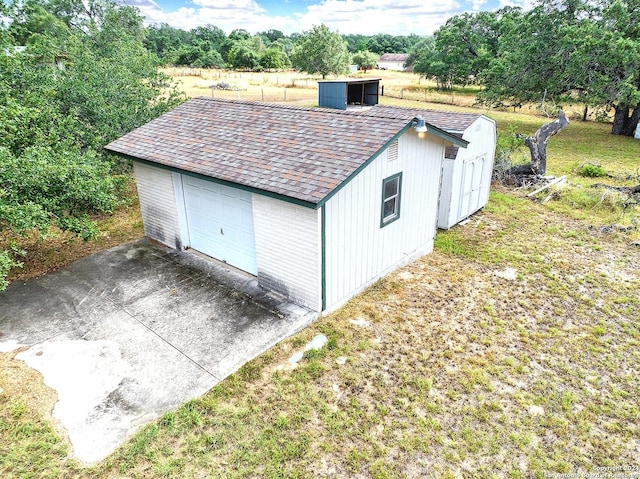 view of outdoor structure with a lawn and a garage