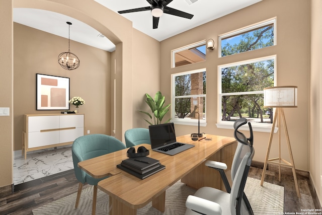 office area featuring dark wood-type flooring and ceiling fan with notable chandelier