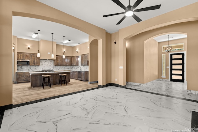 kitchen with a kitchen island, a breakfast bar area, pendant lighting, and decorative backsplash