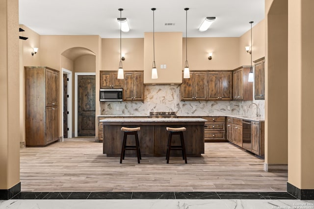 kitchen featuring stainless steel appliances, tasteful backsplash, a kitchen island, and a kitchen breakfast bar