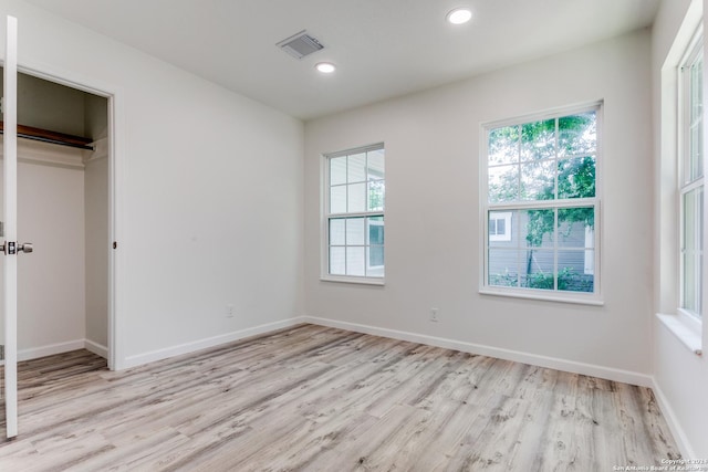 unfurnished bedroom featuring light hardwood / wood-style floors and a closet