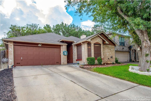 single story home with a front yard and a garage