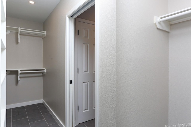 spacious closet with dark tile patterned flooring