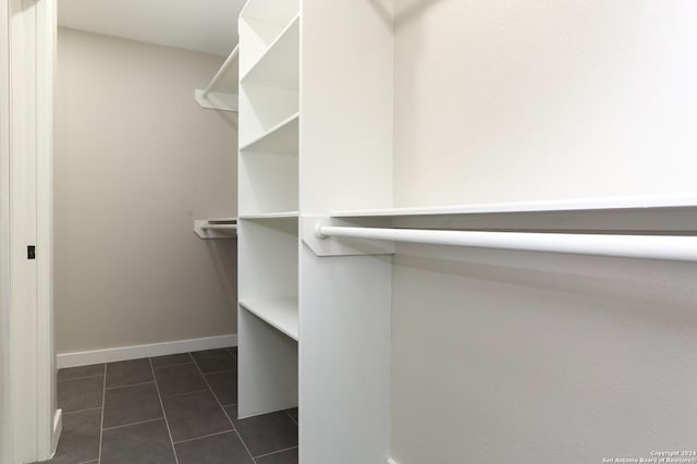 walk in closet with dark tile patterned flooring