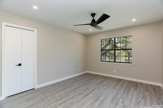 unfurnished bedroom with a closet, ceiling fan, and light hardwood / wood-style flooring