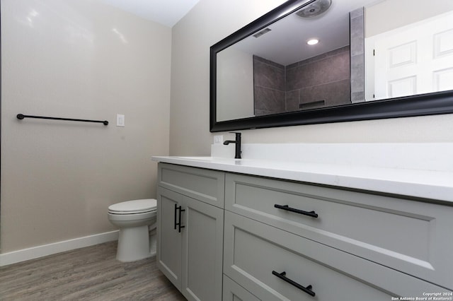 bathroom with hardwood / wood-style floors, vanity, and toilet