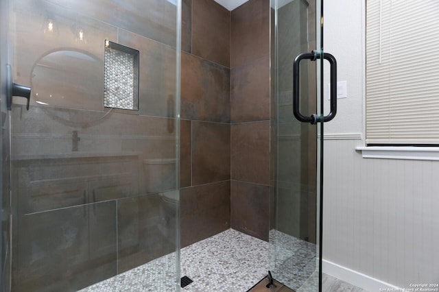 bathroom featuring a shower with door