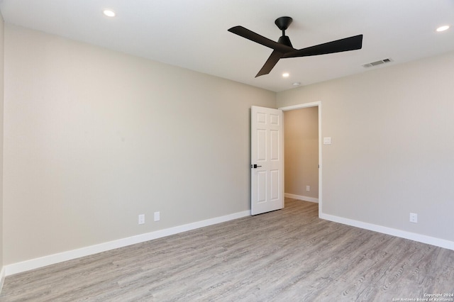 empty room with ceiling fan and light hardwood / wood-style floors