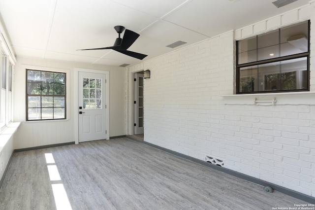 unfurnished sunroom with ceiling fan