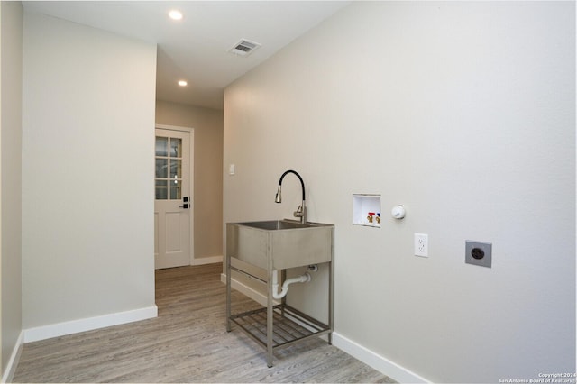 clothes washing area with hookup for an electric dryer, hookup for a washing machine, light wood-type flooring, sink, and hookup for a gas dryer