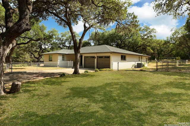 exterior space with a yard, a garage, and cooling unit