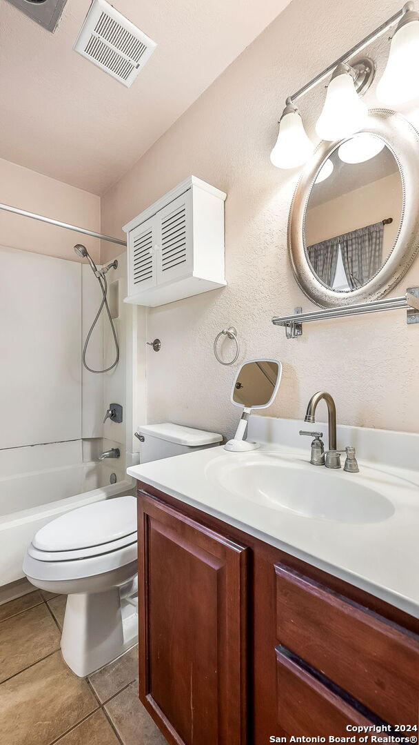 full bathroom featuring tub / shower combination, vanity, tile patterned floors, and toilet