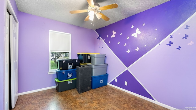 game room featuring ceiling fan and a textured ceiling