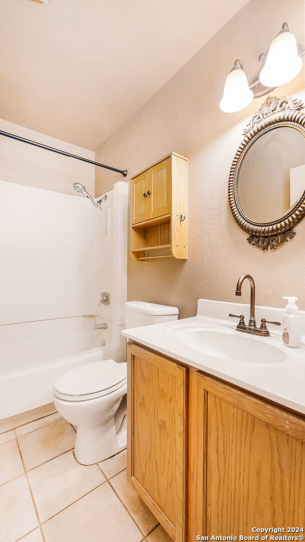 full bathroom featuring tile patterned floors, bathtub / shower combination, vanity, and toilet