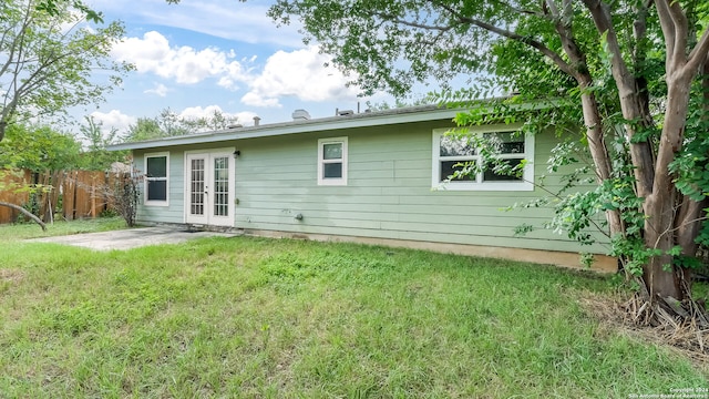 back of property featuring a patio area, french doors, and a lawn