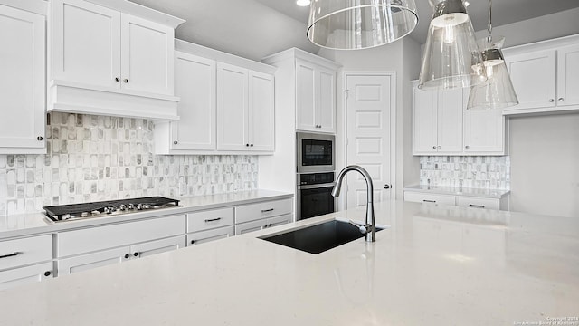 kitchen featuring white cabinetry, sink, pendant lighting, and appliances with stainless steel finishes