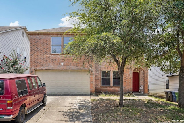 traditional-style home featuring brick siding, driveway, and an attached garage