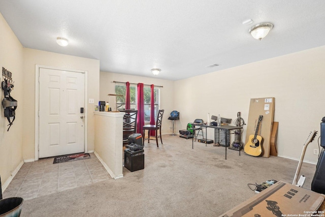 carpeted foyer featuring visible vents, a textured ceiling, and baseboards