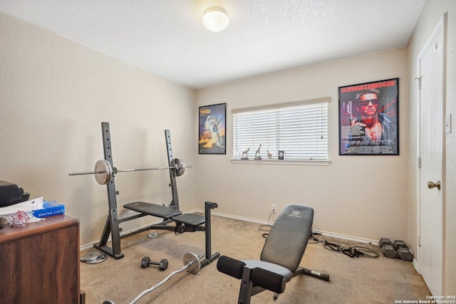 workout room featuring carpet, baseboards, and a textured ceiling