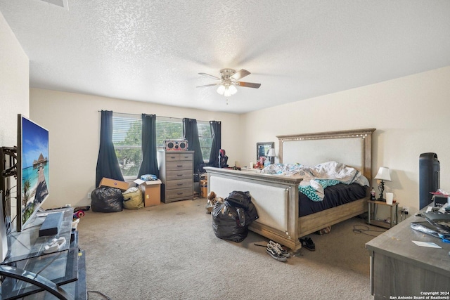 carpeted bedroom featuring a textured ceiling and a ceiling fan