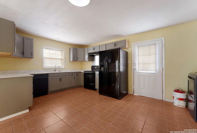 kitchen with black appliances, gray cabinetry, light tile patterned floors, and sink