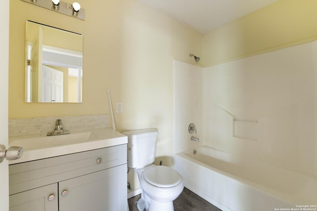 full bathroom featuring toilet, vanity, wood-type flooring, and washtub / shower combination