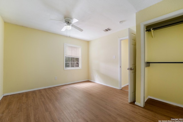 unfurnished bedroom with hardwood / wood-style floors, ceiling fan, and a closet