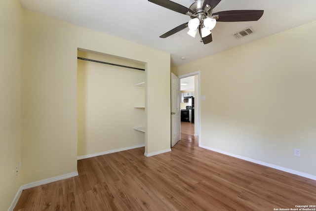 unfurnished bedroom featuring wood-type flooring, a closet, and ceiling fan