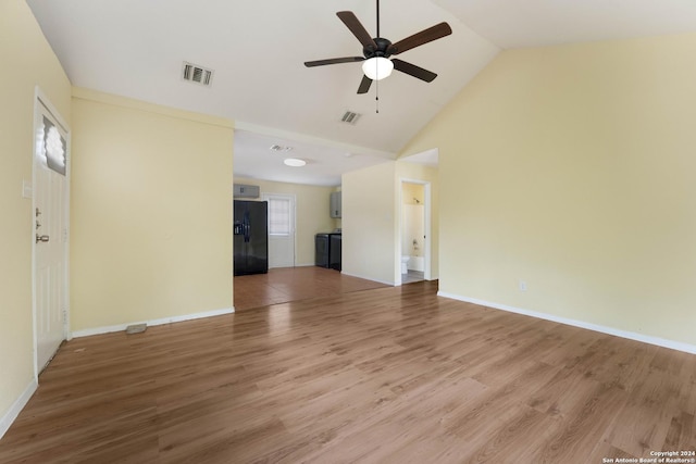 unfurnished living room featuring washer / dryer, ceiling fan, high vaulted ceiling, and hardwood / wood-style flooring