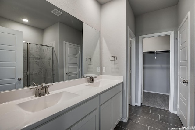 bathroom with tile patterned flooring, vanity, and walk in shower