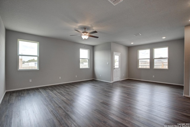 spare room featuring ceiling fan, dark wood-type flooring, and a textured ceiling