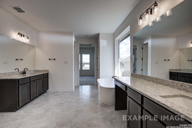 bathroom with vanity and a tub