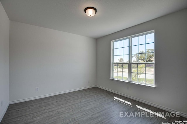 empty room with dark hardwood / wood-style flooring