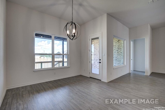 foyer entrance with hardwood / wood-style floors and a chandelier