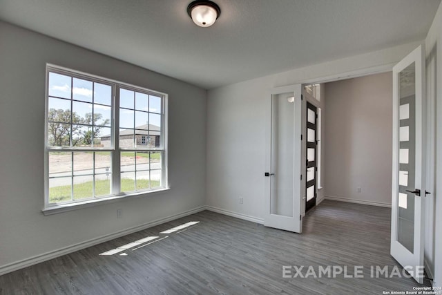 spare room featuring dark hardwood / wood-style flooring and french doors