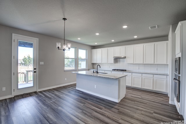 kitchen featuring pendant lighting, sink, white cabinetry, and dark hardwood / wood-style floors