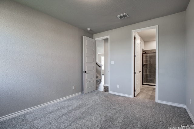 unfurnished bedroom with a textured ceiling and carpet flooring