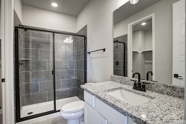 bathroom with toilet, an enclosed shower, and vanity