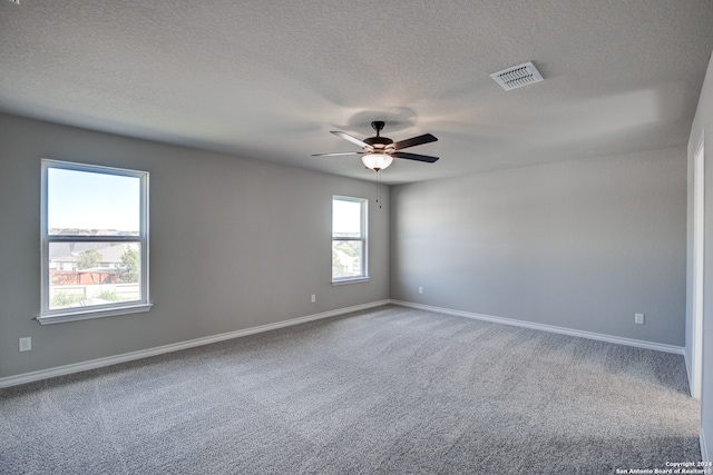 carpeted spare room featuring a textured ceiling and ceiling fan