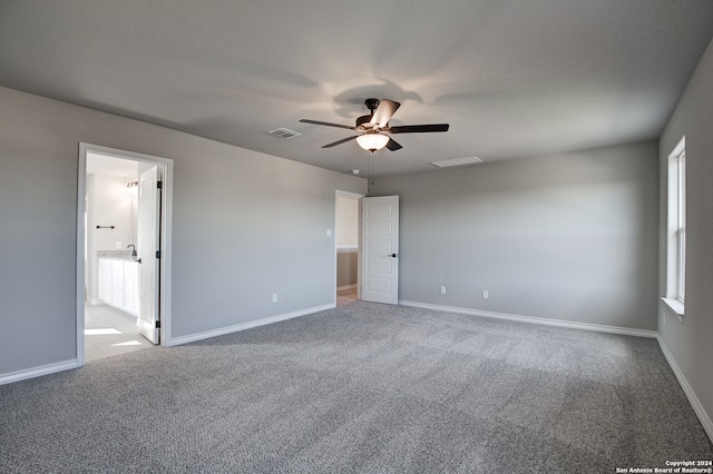 unfurnished bedroom featuring ensuite bathroom, carpet flooring, and ceiling fan