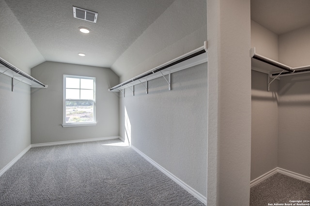 walk in closet featuring vaulted ceiling and carpet floors