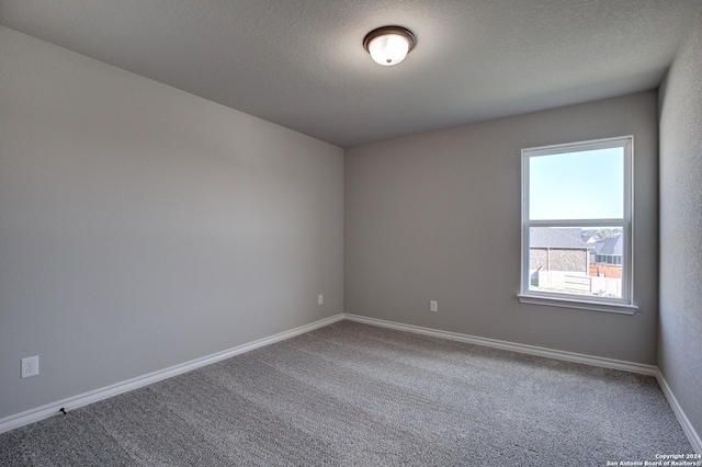 spare room featuring a textured ceiling and carpet floors