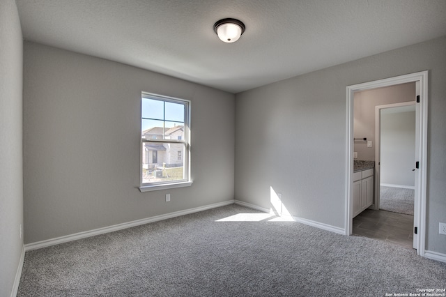 empty room with carpet and a textured ceiling