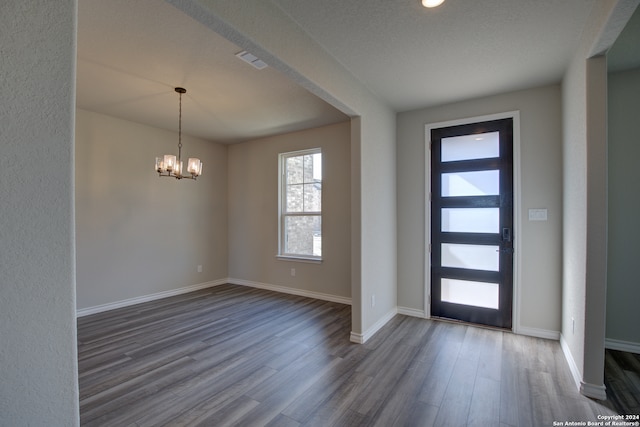 entrance foyer with a notable chandelier, a textured ceiling, and hardwood / wood-style floors