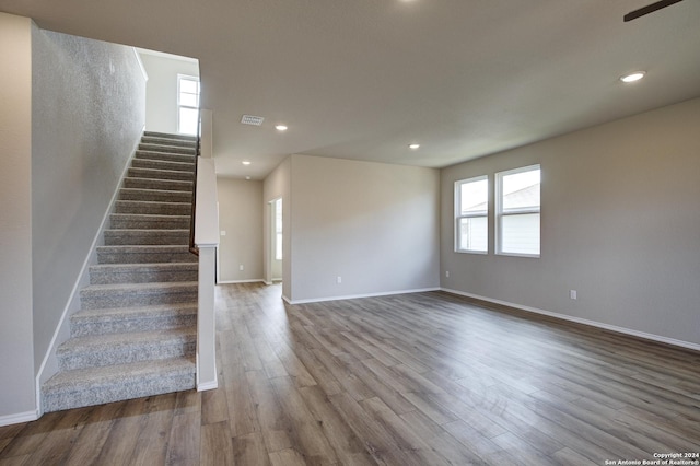 interior space with plenty of natural light, visible vents, baseboards, and wood finished floors