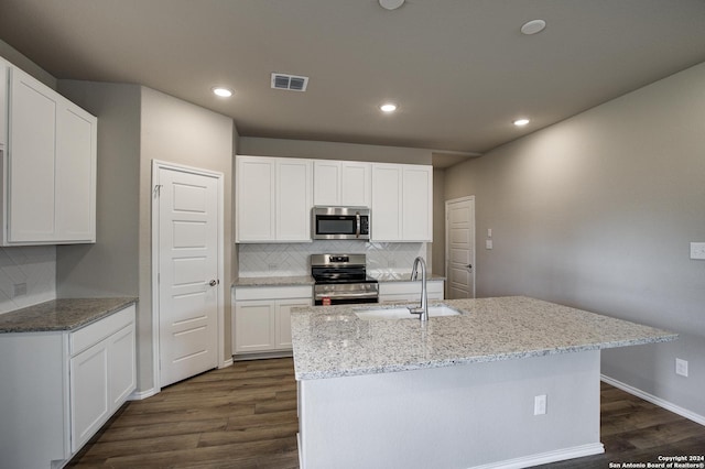 kitchen with a sink, tasteful backsplash, dark wood-style flooring, visible vents, and appliances with stainless steel finishes