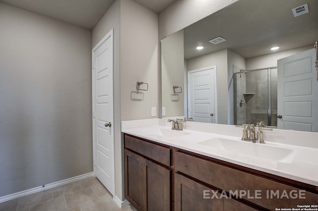 bathroom featuring tile patterned floors, vanity, and a shower with door