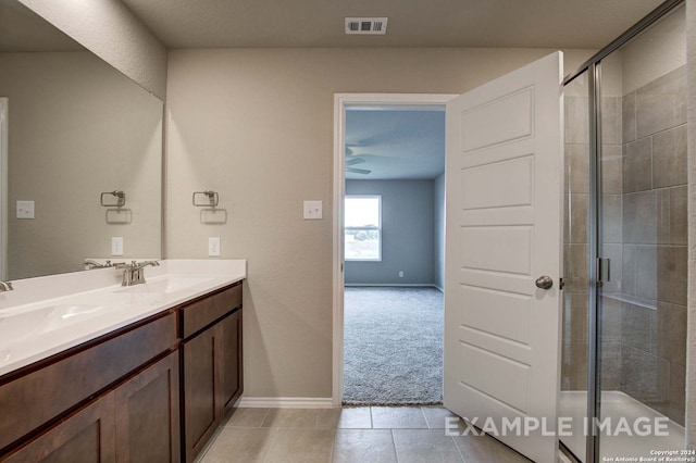 bathroom with tile patterned floors, a shower with door, and vanity